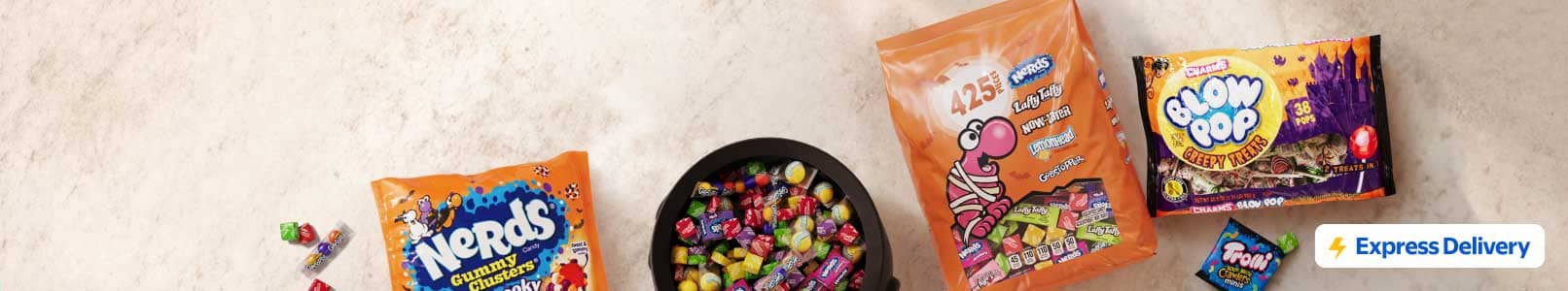 Nerds and Blow Pop Halloween candy bags around a bowl of assorted wrapped candy with an Express Delivery badge.
