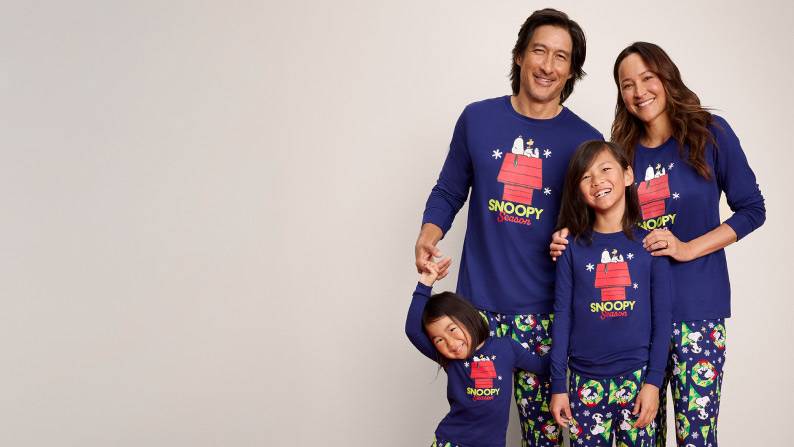 From fifteen dollars. A family of four wearing matching Snoopy pajamas is pictured on a beige backdrop.