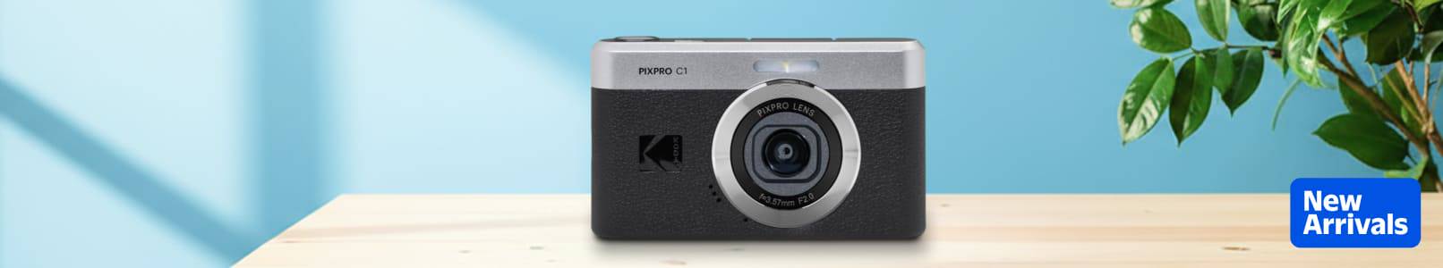 Kodak PIXPRO on a wooden table in front of a teal wall.