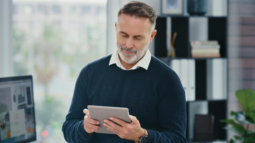 A man in an office using an iPad.
