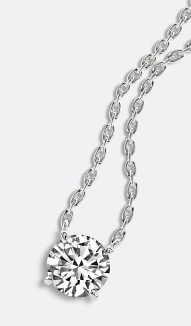A round lab-grown diamond on silver chain is pictured on a light grey backdrop.