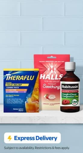 A pack of Hall’s cough drops, Theraflu and a bottle of Robitussin on a white stone counter with a blue tiled wall behind them.