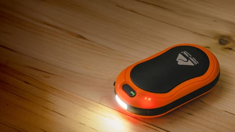 Electric hand warmers on wooden surface.