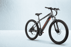 Image shows a gray Huffy Vertis adult electric mountain bike on a light blue background.