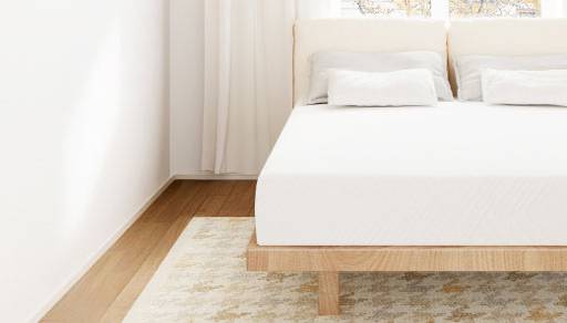 A modern room with a crisply made bed with white linens.