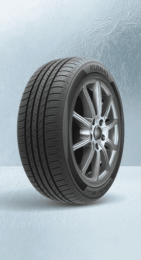 Image shows a black Kumho Crugen HP27 all-season passenger tire on a textured light blue background.