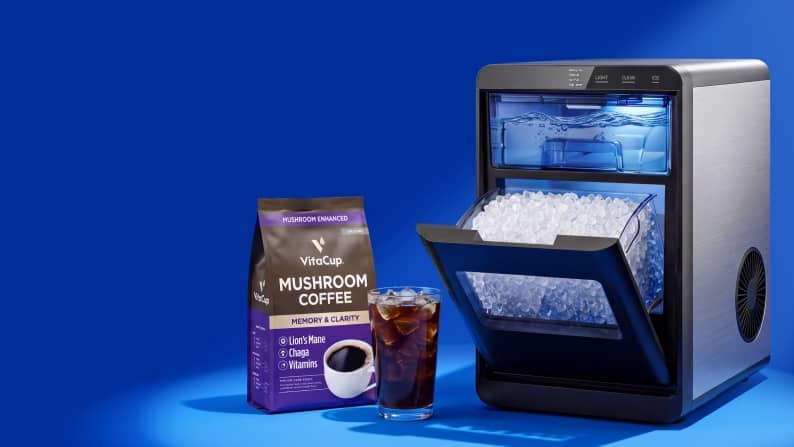 VitaCup Mushroom Coffee bag beside a countertop ice maker filled with ice and a glass of iced coffee.