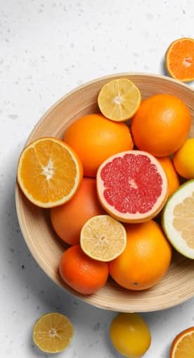 A bunch of oranges, grapefruits, limes and lemons are shown sliced on a white plate.