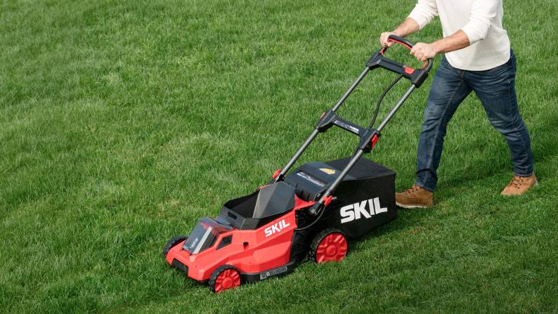 A person mowing a green lawn.