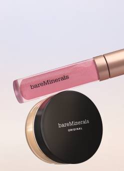 An image of a pink Bare Minerals lip gloss and beige powder foundation shot against a lavender and beige gradient background.