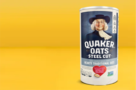 Image shows a white and blue container of Quaker steel-cut hearty traditional oats on a yellow background.
