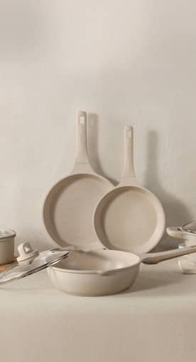 A series of matching beige pans.