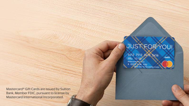 Hands opening a grey envelope with a gift card inside.