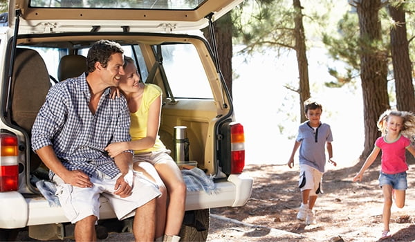 Warm weather auto care Family sitting in back of car in summer