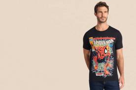 A man wears a black t-shirt with a colorful Spider-Man comic graphic and blue jeans.