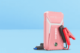 Image shows a pink Gooloo GE1500 car jump starter with red and black clamps on a light blue background.