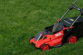 A red lawn mower on a grassy lawn.