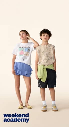 Two tweens stand side by side in casual summer outfits, one in a graphic shirt and skirt, the other in sleeveless top and shorts.
