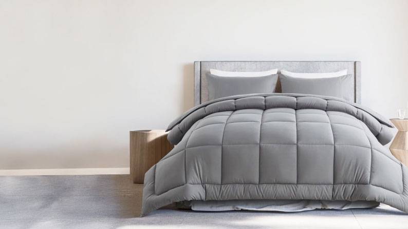 A minimalist grey bed finished with a plush grey quilted duvet and pillow set.