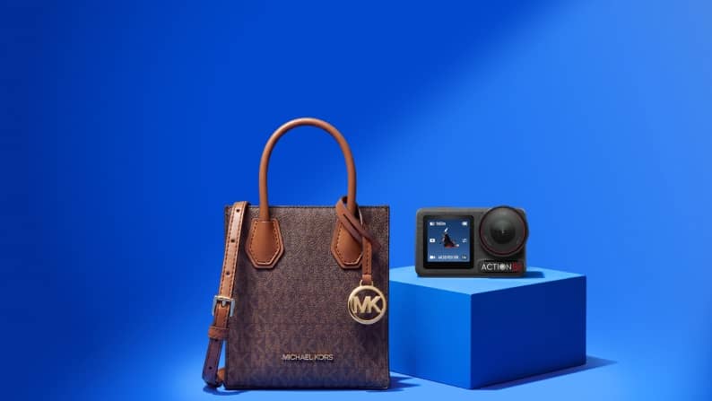 Michael Kors handbag and Actibon action camera on a pedestal.