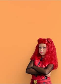 Girl wearing Halloween costume with red wig shown.