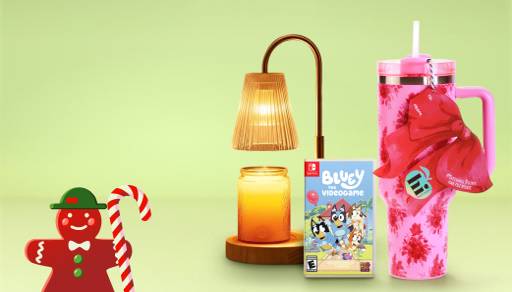 View a pink tumbler with floral patterns, a Bluey video game and a gold candle warmer lamp with a candle underneath.