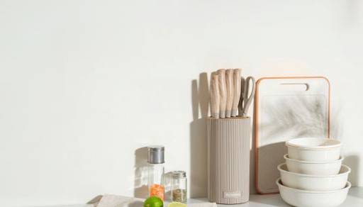 A kitchen counter displaying utensils, bowls and salt and pepper shakers.