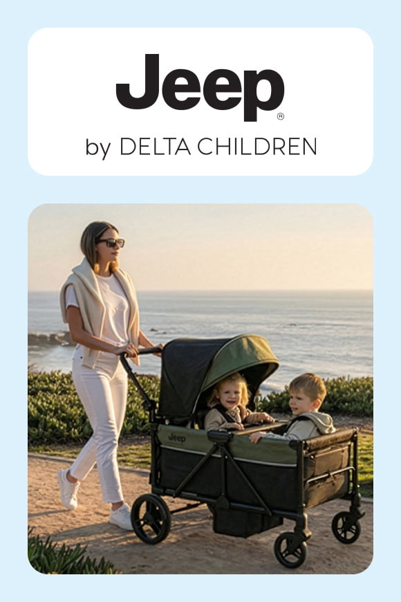 A scenic outside shot of a women pushing two toddlers in a Delta Children x Jeep wagon with other baby gear from this collection—stroller and playard.