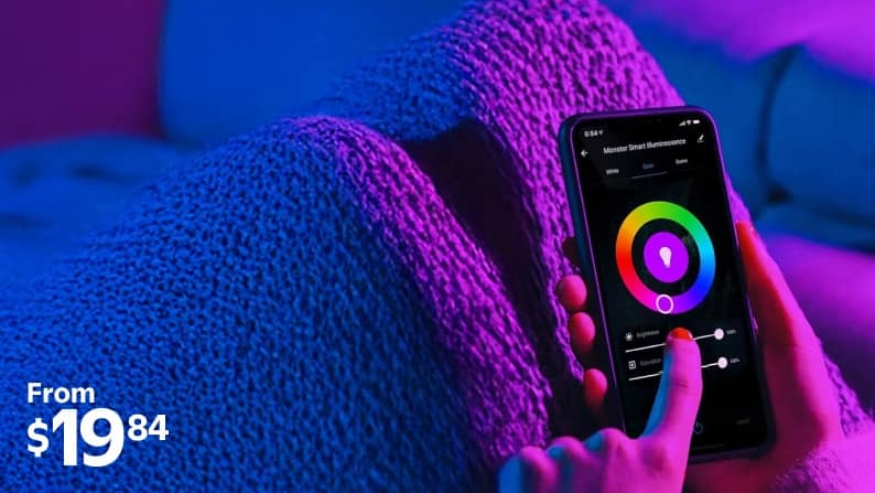 An image of a person using their smart phone to control lighting in a purple-lit room.