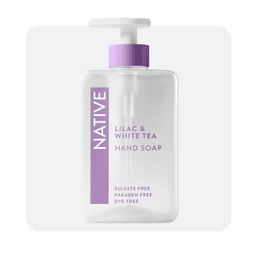 Image shows a clear bottle of Native Lilac & White Tea hand soap with a purple pump, labeled as sulfate-free, paraben-free and dye-free.