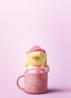 Plush duck inside coffee mug.