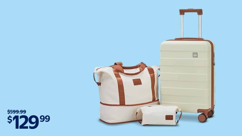 A beige roller suitcase with brown trim is pictured with a matching duffel bag and toiletry case on a blue backdrop.