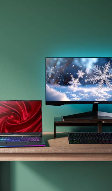 Image shows an open laptop with a red display and a computer monitor with a snowflake display.