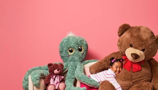 Small plush bear, giant plush octopus and a child hugging a giant-sized plush bear.