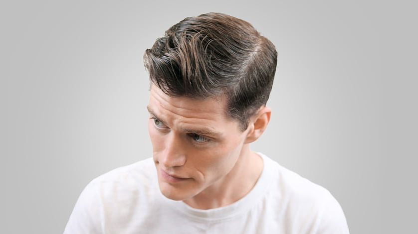A man with short styled hair posing in a white t-shirt