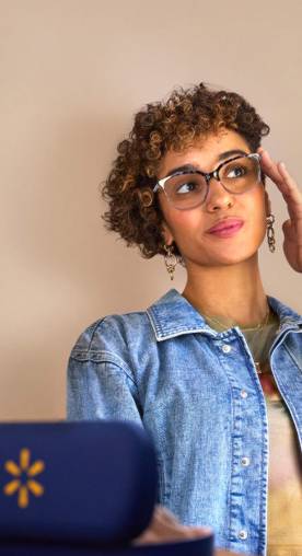 A woman is shown wearing a pair of oversized cat-eye prescription glasses. A Walmart logo case is positioned beside her.