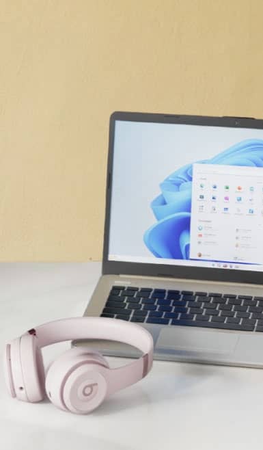 Headphones and a laptop on a desk.