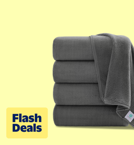 Image shows a stack of dark gray oversized bath towels by Jessy Home on a light yellow background.