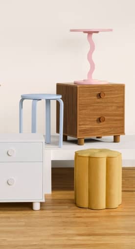 Colorful kids' furniture including a pink wavy table, blue stool, and wood nightstand. Reads: Mix-and-match styles. From twenty-nine ninety-seven.