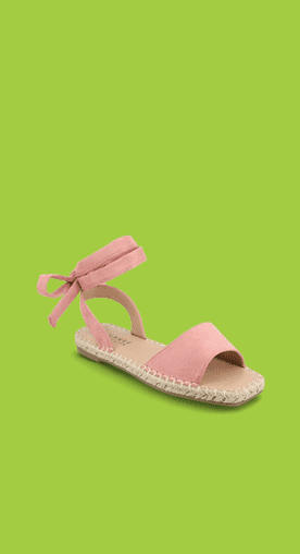 Image shows pink Journee Emelie Espadrille flat sandals with an ankle tie detail on a green background.