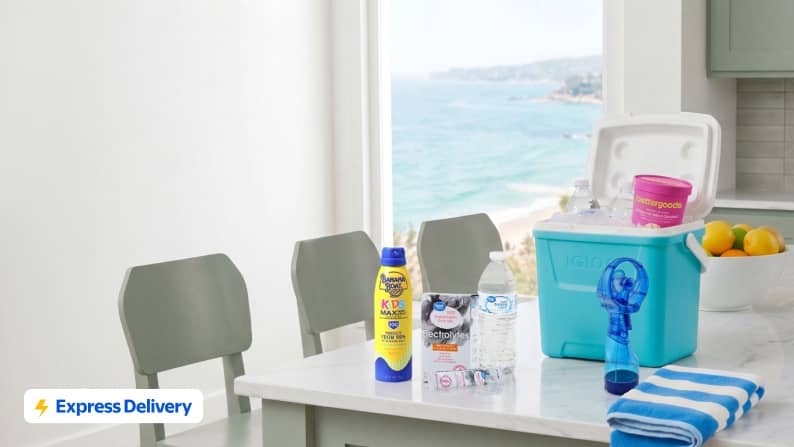 Express Delivery. A mini cooler next to a mini fan, sunblock, a towel, a bottle of water and a box of electrolyte powder.