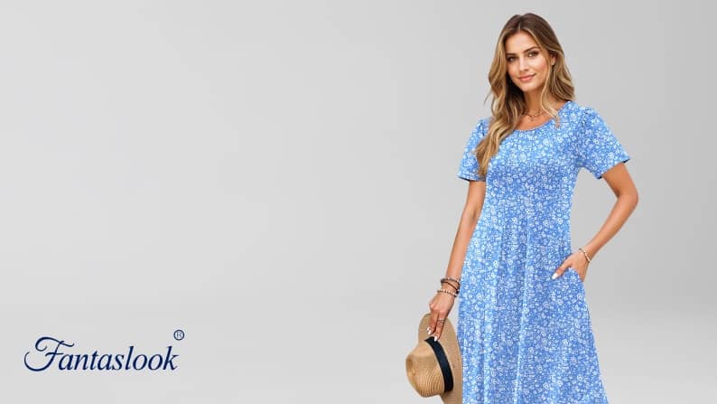 Fantaslook logo. A woman is wearing a blue printed dress and carrying a straw hat with a black ribbon.