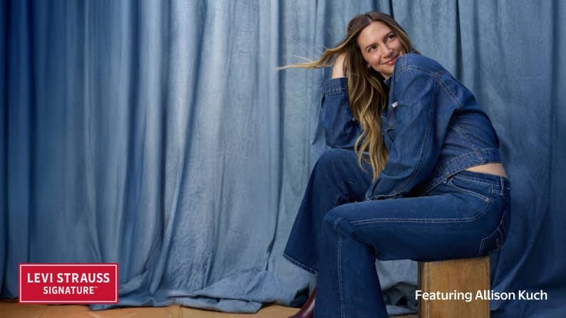 Levi Strauss Signature logo. Allison Kuch is pictured in a denim shirt and jeans sitting on a wooden block against a denim backdrop.