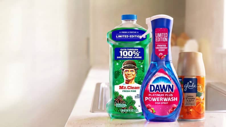 Mr. Clean Fresh Pine cleaner, Dawn Platinum Plus Powerwash frosted cranberry dish spray and Glade orange air freshener on a counter.