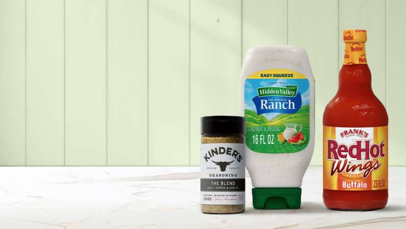 A bottle of ranch, hot sauce and a container of meat seasoning blend are shown.