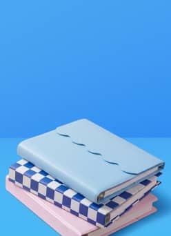 Colorful binders on a blue table, against a blue wall.