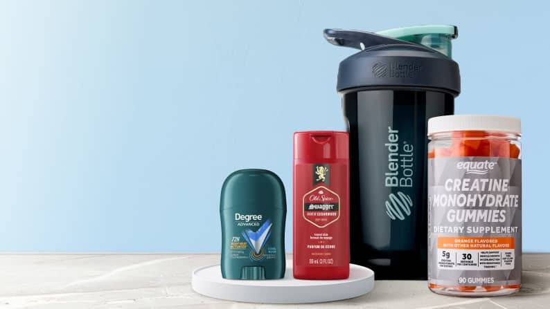 A blender bottle, creatine gummies, deodorant and body wash on a light blue background.
