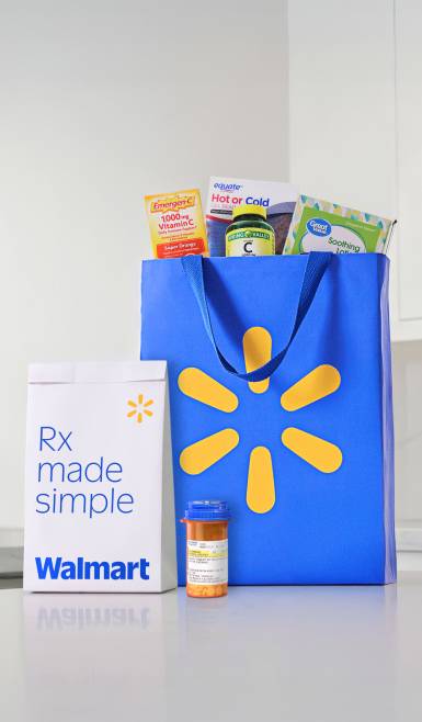 Walmart Rx bag next to a blue Walmart grocery bag full of groceries.