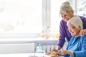 A caregiver assisting an elderly woman.