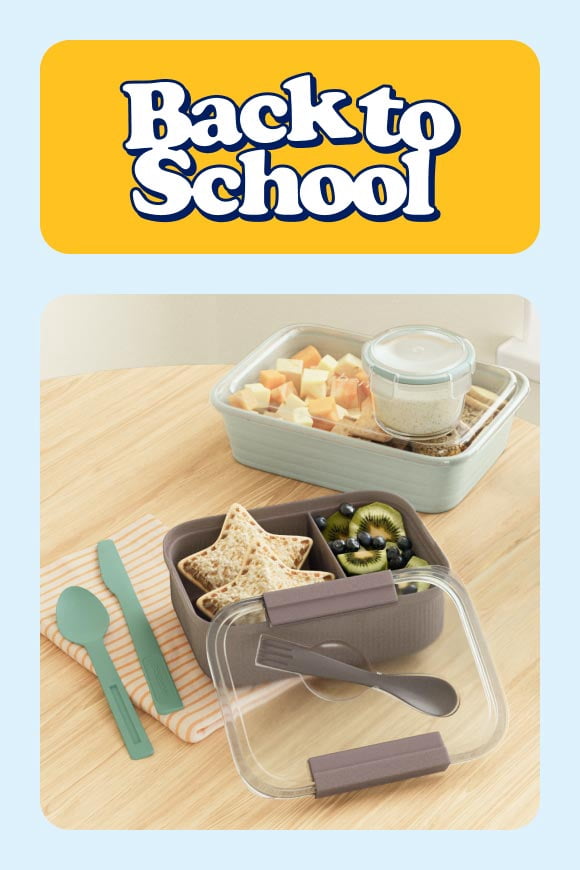 Back to school. Lunch containers filled with sandwich, fruit, cheese cubes, crackers and dip on wooden table with reusable utensils.